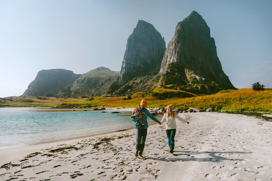 Family walking on the beach - mother, father and infant baby together travel lifestyle in Norway explore Traena islands together, parents and kid having fun bonding love vacations outdoor recreation