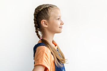 Side profile portrait of a smiling teen girl with braided hair against clean white background, looking ahead with a calm expression and generous copy space © Anastasiya
