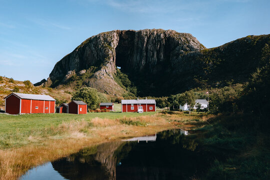Norway landscape with Torghatten mountain and rural wooden houses in Helgeland, scenic Scandinavian countryside summer travel famous natural landmark viewpoint unusual rock with hole