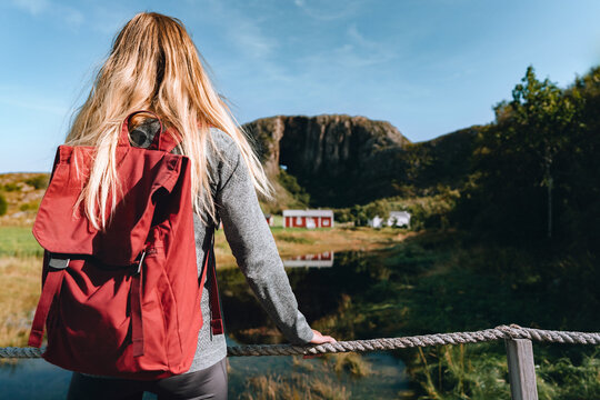 Woman tourist travel solo in Norway female holidaymaker enjoying Torghatten mountain view, active summer vacations adventure lifestyle tour explore Helgeland natural landmarks outdoors