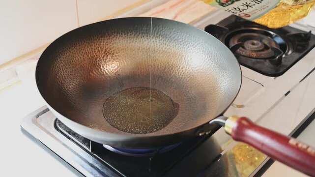 Pouring Cooking Oil into a Hot Traditional Iron Wok