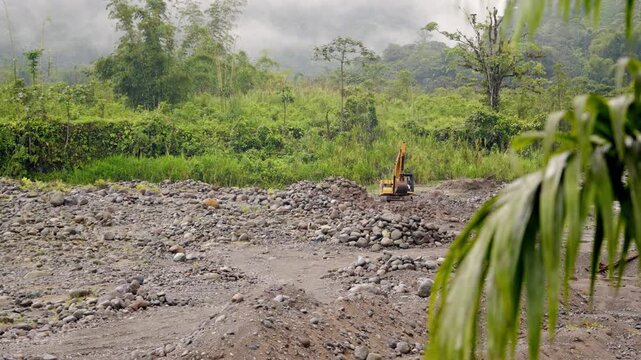 excavadora minando alado de un rio en la selva del Ecuador 