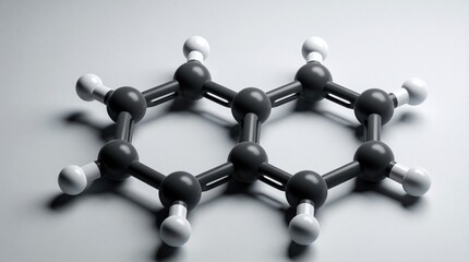 Obraz premium 3D model of naphthalene molecule with two fused benzene rings. Black carbon atoms, white hydrogen atoms connect via chemical bonds. Organic compound structure shows hexagonal aromatic ring pattern