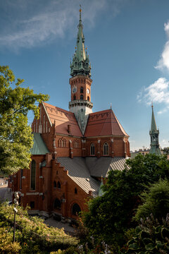 Krakow, Poland - July 18, 2026: Low-angle side view of the red-brick Neo-Gothic St. Joseph&rsquo;s Church in Podgorze.