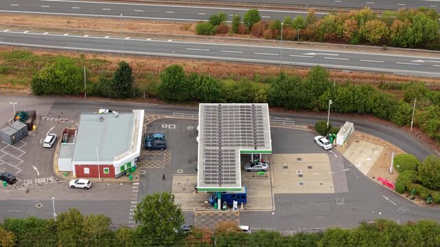 Aerial view of busy petrol station forecourt with queuing traffic waiting for fuel in Bedford, UK