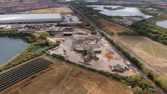 Aerial view of an asphalt manufacturing plant and aggregate processing facility with heavy machinery in Bedford, UK