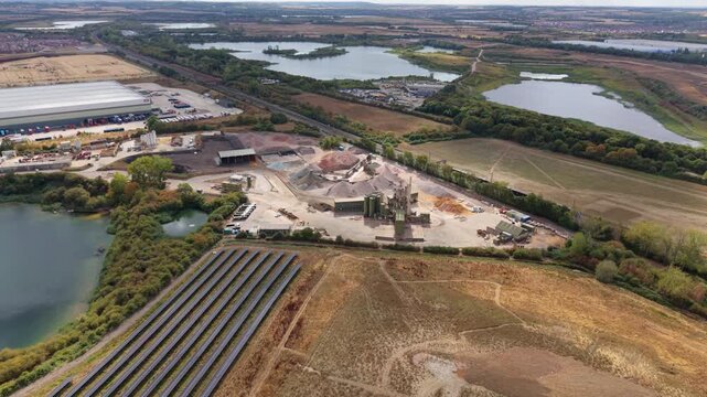 Aerial view of an asphalt manufacturing plant and aggregate processing facility with heavy machinery in Bedford, UK