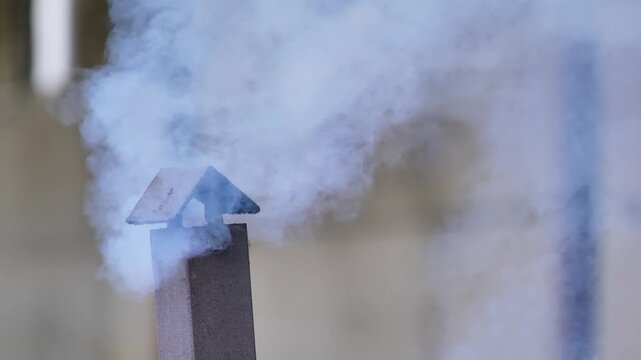 Smoke rising from a chimney on a farm, indicating heating and air pollution