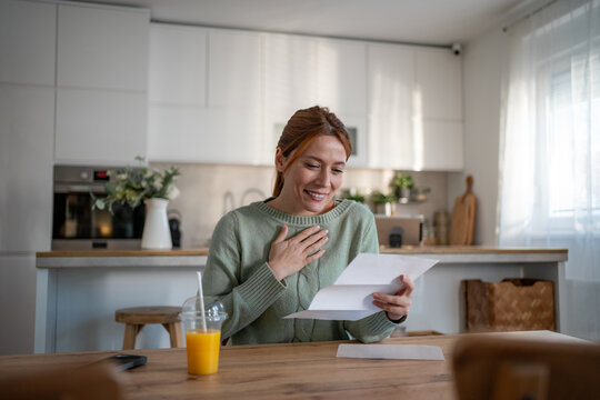Woman receiving good news reading letter at home