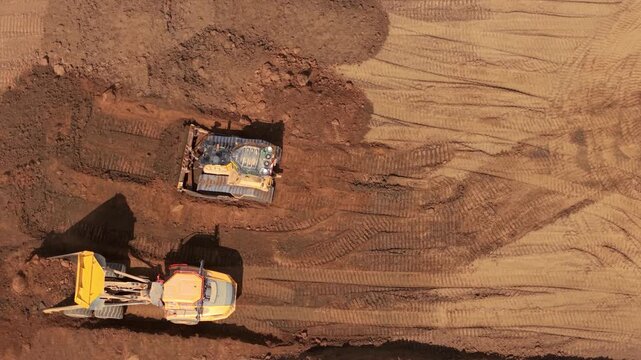 Aerial view of heavy earthmoving machinery moving soil spoil during major highway construction in Bedfordshire, UK