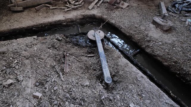 Manure scraper system inside a dirty cattle barn with drainage gutter