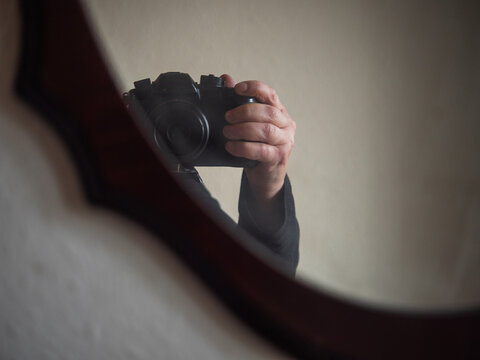 Hand with camera taking photo in mirror