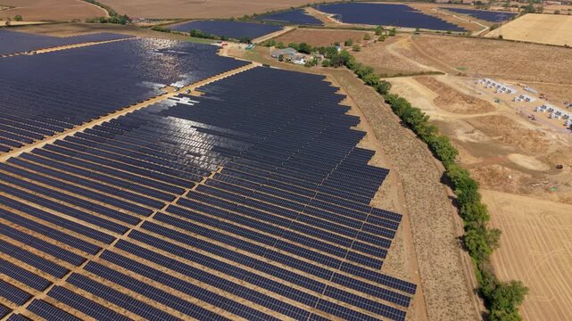 Aerial view of expansive photovoltaic solar farm array with an access road cutting through the middle near Eaton Socon, UK