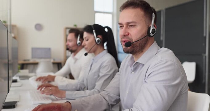 Operator agent support headset call customer service. Team in an office uses computer to assist clients by phone, managing queries and providing solutions. Teamwork and support concept.