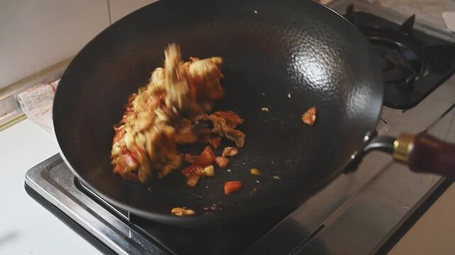 Stir Frying Tomatoes with Scrambled Eggs in an Iron Wok