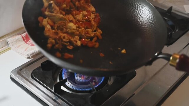 Stir Frying Tomatoes with Scrambled Eggs in an Iron Wok