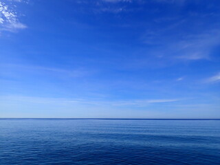 Obraz premium Minimal Blue Sky and Waves Horizon. Sea to the horizon and blue sky with clouds, Mediterranean Sea. Aerial view of blue sea and sky landscape. Landscape beautiful summer vertical Horizontal look view.