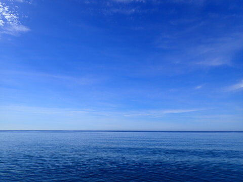 Minimal Blue Sky and Waves Horizon. Sea to the horizon and blue sky with clouds, Mediterranean Sea. Aerial view of blue sea and sky landscape. Landscape beautiful summer vertical Horizontal look view.