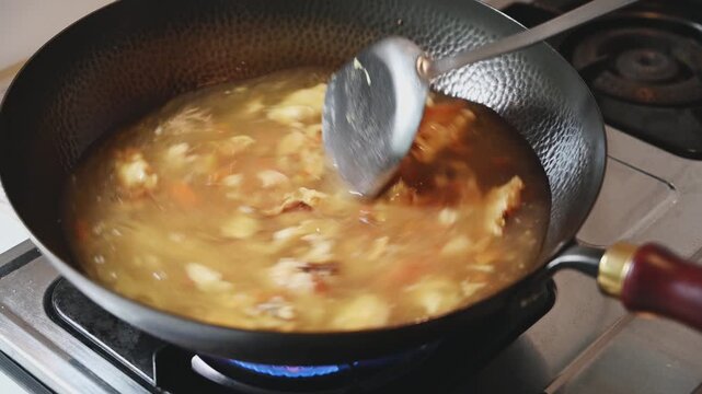 Boiling Tomato and Egg Soup in a Traditional Iron Wok