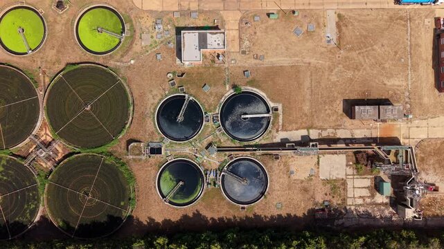 Top down aerial view of circular clarifiers and trickling filter beds at a wastewater treatment plant in St Neots, UK