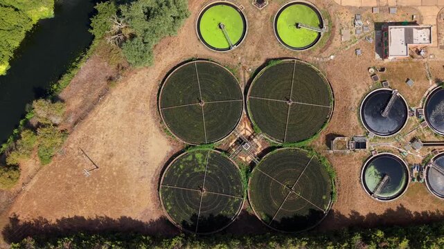 Top down aerial view of circular clarifiers and trickling filter beds at a wastewater treatment plant in St Neots, UK