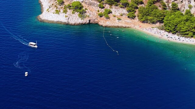 Aerial view of a beautiful beach with turquoise water and boats in Brela, Croatia