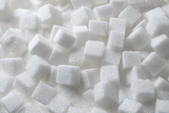 Scattered white sugar cubes macro background
