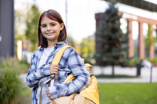 Smiling schoolgirl with backpack ready for school