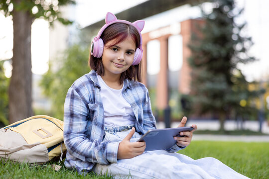 Young girl learning outdoors using digital tablet