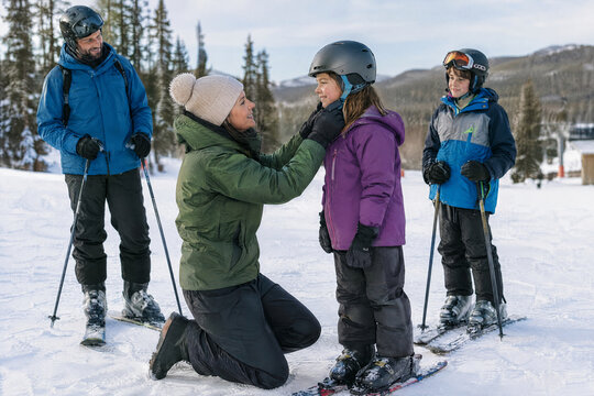 Family preparing for a ski day by putting on winter gear