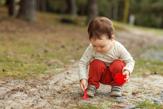 Toddler playing with sand during sensory play outdoors