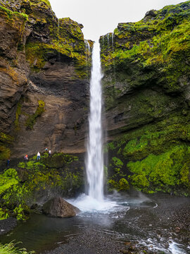 The Kverna River cascades down over the lava cliffs. Kvernufoss waterfall is located in Kvernugil gorge and is partially concealed by moss-coated black volcanic rock. Evindarh&oacute;lar, South Iceland.