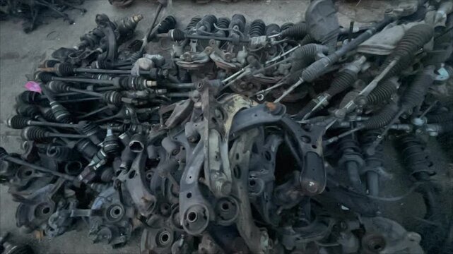 Old Automotive Spare Parts and Steering Components in Auto Salvage Yard, automotive spare parts, steering racks, suspension components, control arms