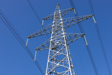 Obraz premium Low angle view of high voltage electric transmission pylon and cables