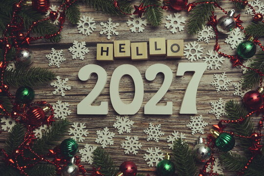 Hello 2027 alphabet letters with Christmas decoration on wooden background
