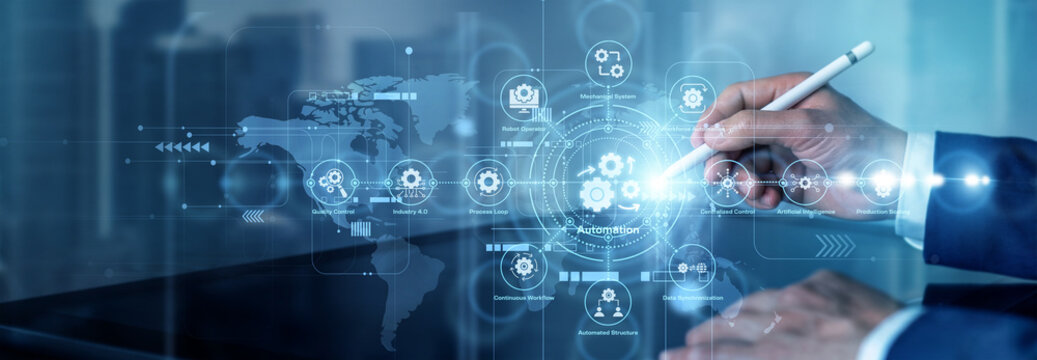 A process engineer points to a digital network display showing automated workflows, robotic tasks, and trigger icons. Automation reduces repetitive work through coordinated digital processes.