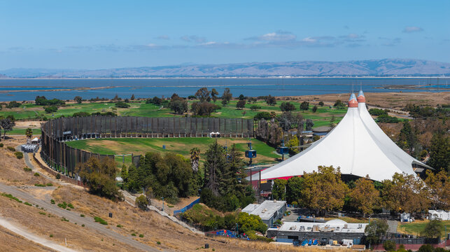 Aerial view of the white Google canopy at Shoreline Amphitheatre and the adjacent golf course driving range near the bay waters in Mountain View, California.