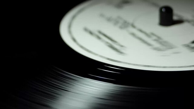 Close-up of spinning vinyl record label in soft studio light with cinematic motion for retro music concept