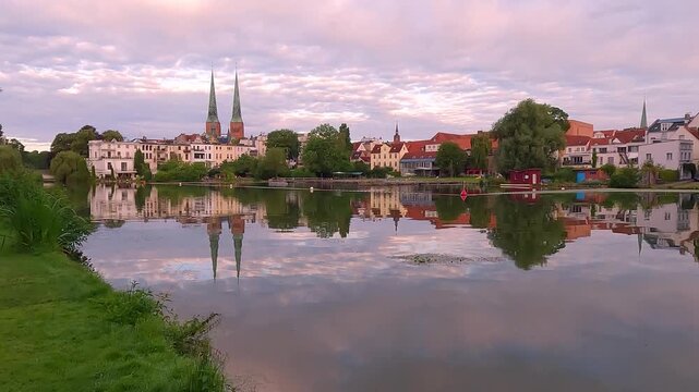 Calm summer cityscape of Lubeck town with twin spires rise from this austere cathedral, founded in 1173, reconstructed after bombing in 1942, Germany, Europe. 4K video (Ultra High Definition).
