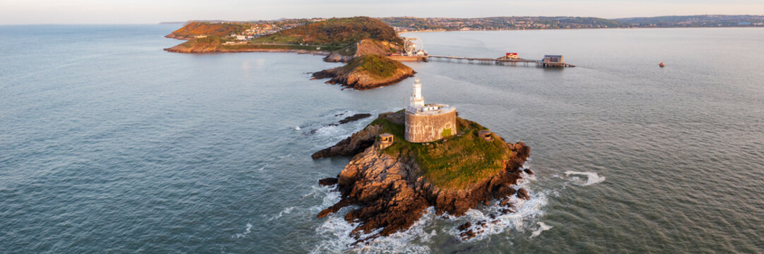 Mumbles Lighthouse on rocky island at sunrise in swansea Wales