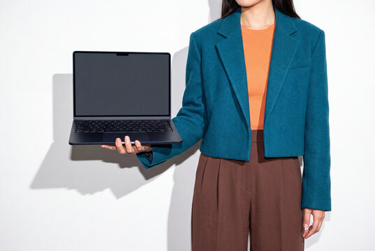 Businesswoman Balancing Laptop on Palm