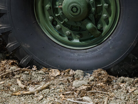 Detail of a truck tire stuck in mud with a green hub.