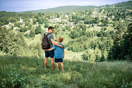 Father and son hiking together in nature, family bonding, fatherhood, adventure, healthy lifestyle and outdoor travel concept
