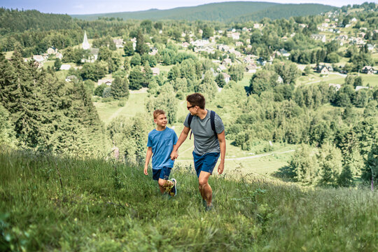 Father and son hiking together in mountains, fatherhood, parenting, family bonding, healthy lifestyle and outdoor adventure concept
