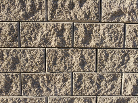 Rough concrete block wall texture with relief surface. Modern exterior split-face stone background