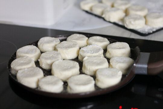 Homemade syrnyky frying in a pan during breakfast preparation