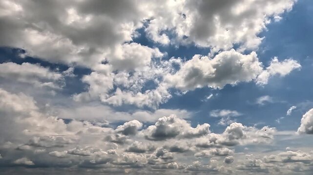 Flowing rainy clouds in the blue skies. 4K video (Ultra High Definition) of cloudscape. Sky and clouds Timelapse. Sun shines through the dramatic clouds on the blue sky background.