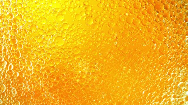 Super Slow Motion Shot of Swirling Golden Oil Bubbles in Water at 1000fps. Cosmetic Background.