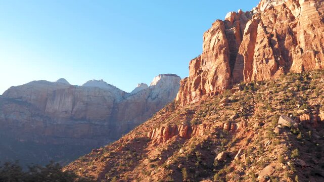 Picturesque red rock formations of zion national park in utah seen from moving vehicle during scenic drive at sunrise, revealing canyon majestic and layered landscape