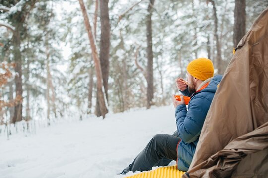 Man eating hot meal during winter solo camping